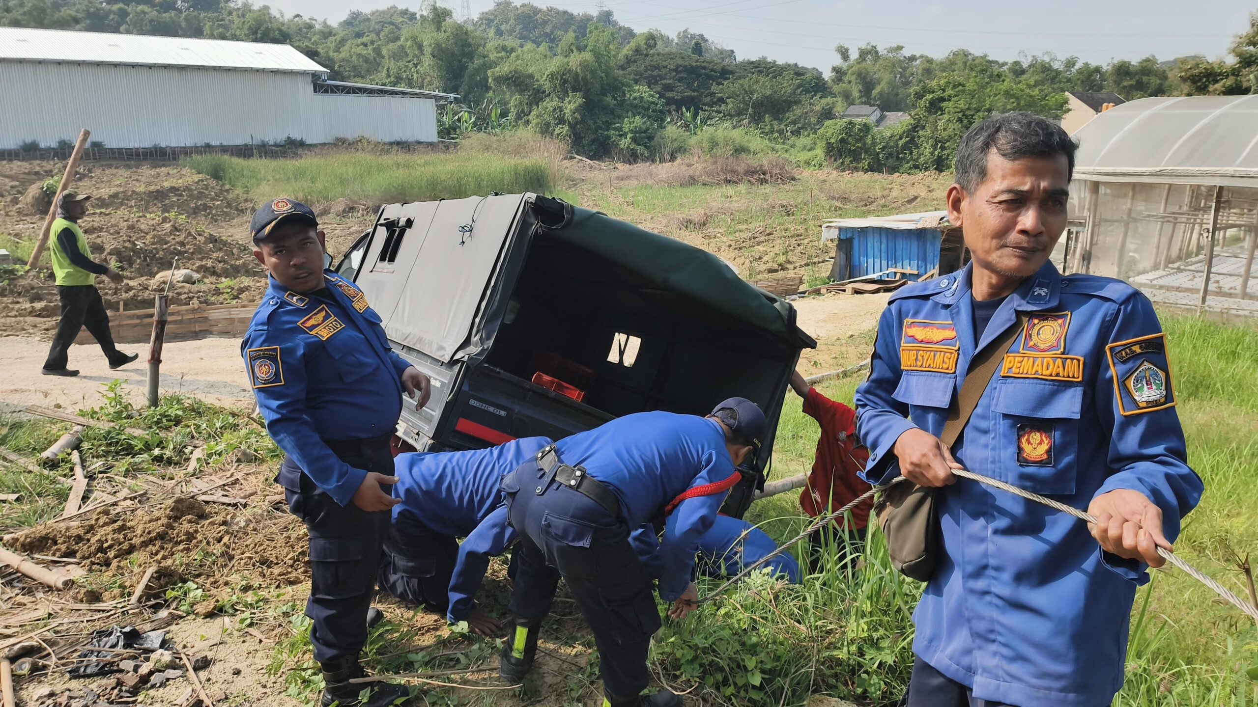 Petugas damkar melakukan evakuasi mobil pikap yang terperosok di Sekarkurung, Gresik.