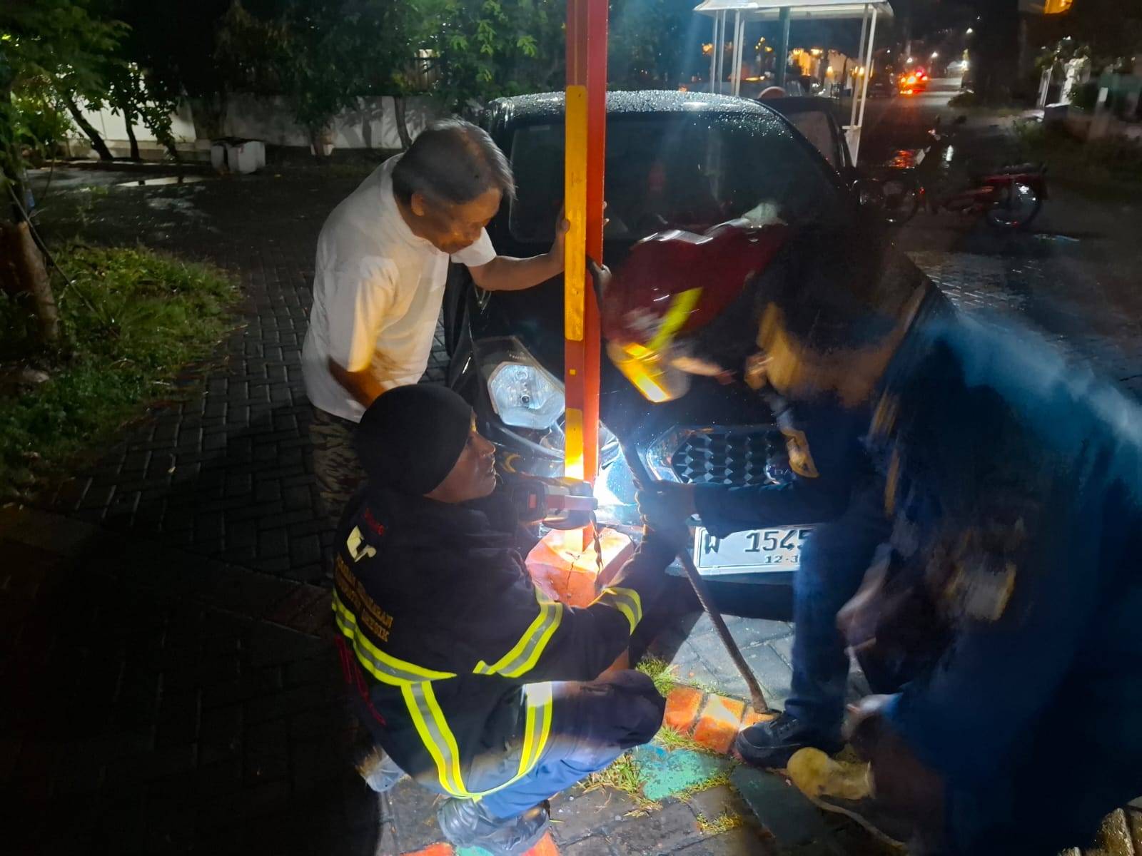 Petugas Damkar melakukan evakuasi mobil tersangkut portal di Gresik.