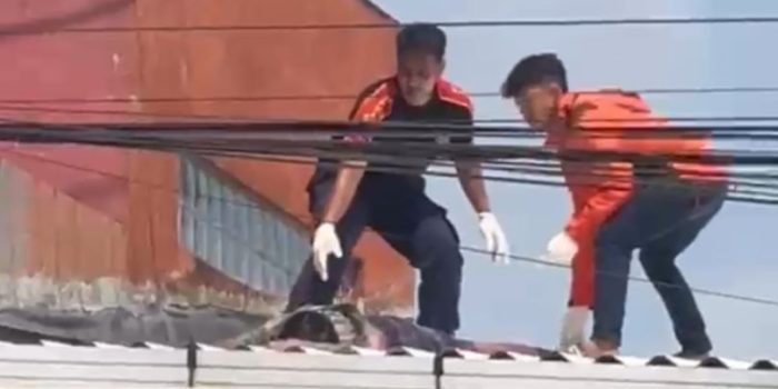 Tim Damkar saat mengevakuasi bocah di atap sebuah toko. (Ist)