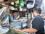 Riski saat melayani pembeli plastik. (Foto: Achmad Adi Nurcahya)