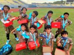 Para pemain SSB Gressia U-12 berpose sambil memperlihatkan sepatu sepak bola yang dibagikan kepada seluruh peserta Freeport Grassroots Tournament 2026 di Gresik, dengan total 300 pasang sepatu.