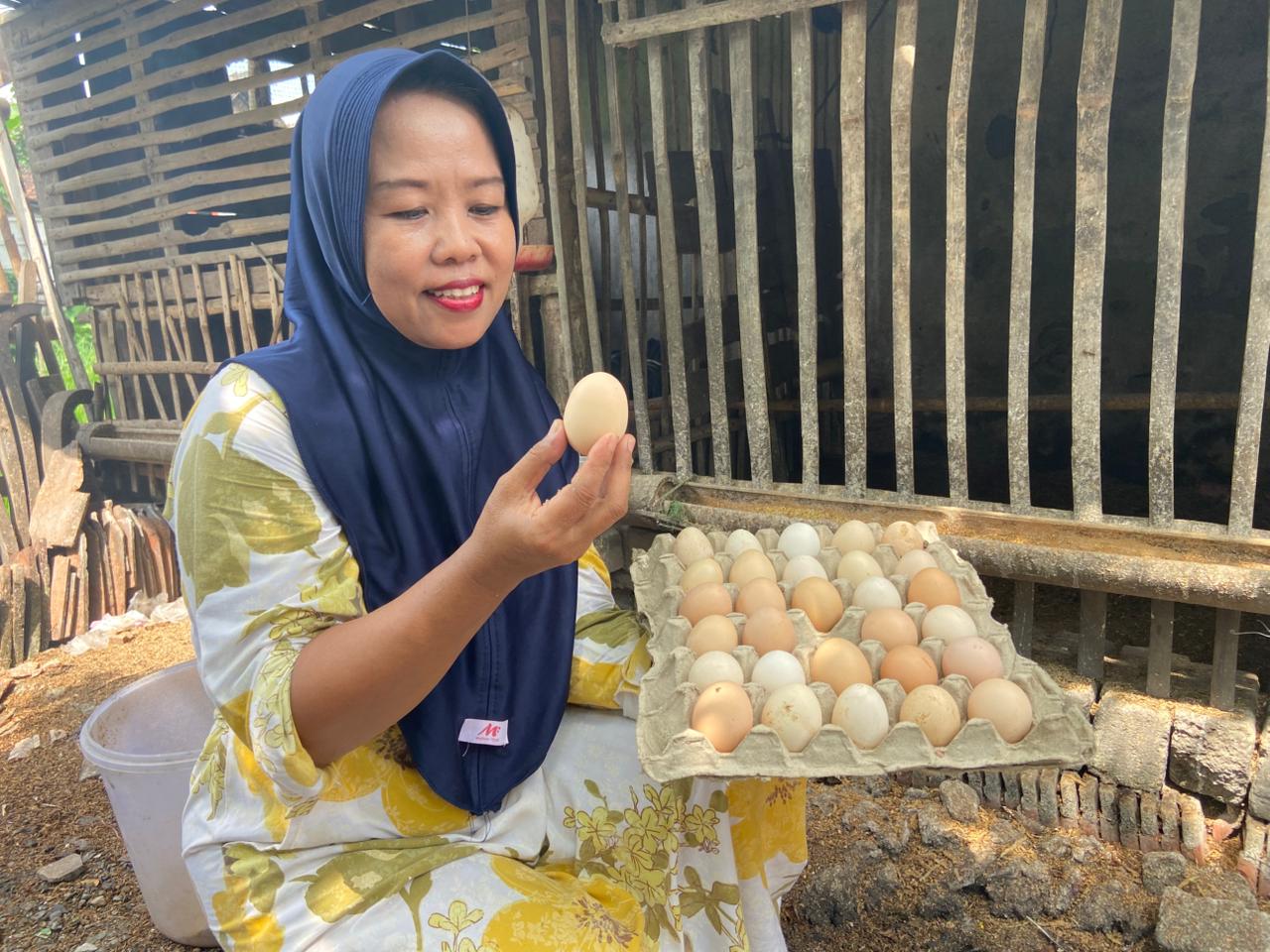 Siti Linarsih, anggota Kelompok Jengkar Mandiri menunjukkan telur ayam kampung hasil produksinya.
