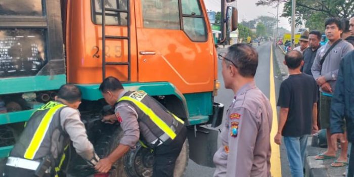 Petugas evakuasi korban di sela ban truk.