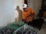 Suparlan saat membungkus petis kupang produksinya. (Achmad Adi Nurcahya)