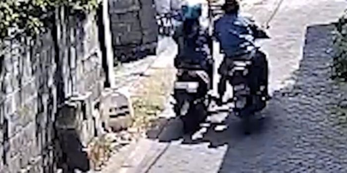 Tangkapan layar rekaman CCTV seorang pria dan wanita mendorong motor diduga curian. (Foto: Ist)