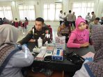 Anggota TNI dan Bhayangkari saat mengikuti donor darah HUT ke-80 Bhayangkara di Polres Gresik.