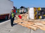 Truk muatan triplek terguling di jalan tol.