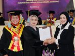 Kepala LLDIKTI Wilayah VII Jawa Timur, Prof. Dr. Dyah Sawitri, S.E., M.M. (kanan), menyerahkan Surat Keputusan (SK) Guru Besar kepada Prof. Dr. Sri Astutik, S.H., M.H. (tengah), didampingi Rektor Universitas Dr. Soetomo (Unitomo), Prof. Dr. Siti Marwiyah, S.H., M.H. (kiri), dalam rangkaian Sidang Senat Terbuka Pengukuhan Guru Besar di Auditorium K.H. Moh. Saleh, Unitomo