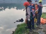 Petugas relawan saat mengevakuasi mayat dari sungai.(istimewa)