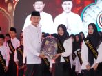 Bupati Lamongan Yuhronur Efendi menyerahkan penghargaan kepada hafidz muda. (Foto: Ist) Bupati Lamongan Yuhronur Efendi menyerahkan penghargaan kepada hafidz muda. (Foto: Ist)