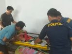 Petugas Sidokkes Polres Gresik membantu warga yang sakit untuk berobat.