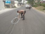 Kapolsek Balongpanggang AKP Wiwit Mariyanto saat menandai jalan berlubang.