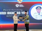 Menteri P2MI Mukhtarudin menyerahkan penghargaan kepada Bupati Gresik Fandi Akhmad Yani.