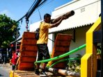 Petugas gabungan dari Pemkab Nganjuk bersama sejumlah teknisi ISP saat memotong dan menata ulang kabel fiber optik yang semrawut di salah satu sudut jalan Kabupaten Nganjuk.