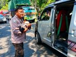 IMG-20260706-WA0014 Aipda Sutrisno, Bhabinkamtibmas Polsek Bagor, dengan wajah panik saat menggendong dan melarikan bayi yang selamat dari bus tercebur sungai ke dalam ambulans di Jembatan Paron, Nganjuk