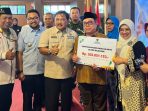 Bupati Nganjuk, Marhaen Djumadi didampingi Ketua Baznas Nganjuk, Zainal Arifin, saat menyerahkan santunan secara simbolis di Pendopo KRT Sosrokoesoemo.