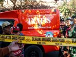 Petugas memasang police line di lokasi penemuan jenazah Gatot di Dusun Nanggungan, Desa Kaloran, Kecamatan Ngronggot (Agus Karyono)