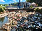 IMG-20260720-WA0010 Petugas gabungan Dinas PUPR Nganjuk dan BBWS Brantas saat mengevakuasi tumpukan sampah yang menyumbat Saluran Irigasi B21 di Kelurahan Plosorejo, Nganjuk