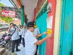 Petugas Pemkab Mojokerto memasang stiker penertiban pada kios yang menunggak retribusi di Pasar Raya Mojosari (istimewa)