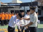 Kepala Rutan Kelas IIB Nganjuk, Arief Budi Prasetya, memberikan dokumen remisi kepada perwakilan anak binaan pada Peringatan Hari Anak Nasional 2026 di halaman Rutan Kelas IIB Nganjuk