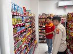 Anggota bersama pegawai cek rak toko.