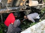 Petugas gabungan dibantu warga mengevakuasi jenazah korban yang tertimpa bodi truk ekspedisi