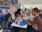 Suasana antrean SIM Keliling 24 Jam yang baru pertama kali dioperasikan di depan McD Taman Pinang, Sidoarjo. (Foto: Achmad Adi Nurcahya)
