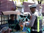 Anggota Satlantas Polres Gresik membagikan nasi bungkus kepada warga. Foto: Ist)