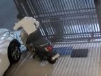 Pelaku saat berupaya mengeluarkan sepeda motor korban. (Foto: Ist) Pelaku saat berupaya mengeluarkan sepeda motor korban. (Foto: Ist)