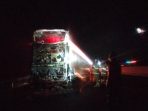 Petugas pemadam kebakaran Damkar Nganjuk dan Madiun melakukan proses pembasahan pada bangkai bus Gunung Harta yang ludes terbakar di KM 631 Tol Nganjuk