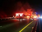 Petugas gabungan saat melakukan proses pembasahan pada bangkai bus tingkat Gunung Harta yang ludes terbakar di kawasan Nganjuk