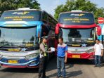 Petugas Satlantas Polres Nganjuk memberikan sanksi tilang di tempat kepada pengemudi bus AKAP/AKDP yang nekat menerobos jalur dalam kota di Jalan Panglima Sudirman, Nganjuk