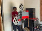 Slamet Pujiono menunjukkan proyektor film 35 milimeter produksi sekitar 1980 yang masih disewakannya untuk hiburan warga.(teguh)