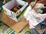 Perajin Batik Tulis Jati Waras asal Desa Jatigreges, Kecamatan Pace, Nganjuk, saat mencanting kain batik tulis dengan ketelitian tinggi di kediaman pasutri Yatilah dan Yulianto.