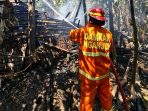 Petugas Damkarmat Kabupaten Nganjuk melakukan proses pendinginan pada sisa-sisa reruntuhan dapur dan kandang ternak milik Abdul Manan di Dusun Wates, Desa/Kecamatan Baron, Nganjuk