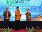 Bupati Gresik Fandi Akhmad Yani (tengah) didampingi Kepala DPMPTSP Reza Pahlevi (paling kiri) menyerahkan penghargaan kepada Sekretaris Perusahaan Petrokimia Gresik Nuril Huda. (Foto: Ist/Komkor PG) Bupati Gresik Fandi Akhmad Yani (tengah) didampingi Kepala DPMPTSP Reza Pahlevi (paling kiri) menyerahkan penghargaan kepada Sekretaris Perusahaan Petrokimia Gresik Nuril Huda. (Foto: Ist/Komkor PG)