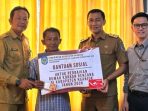 nganjuk Kepala Dinas PRKPP Kabupaten Nganjuk, Mashudi Nurul Huda, menyerahkan bantuan sosial perbaikan rumah terdampak bencana secara simbolis