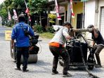 Petugas Tim URC PJ Kertobaworo Dinas PUPR Kabupaten Nganjuk melakukan penambalan aspal panas di ruas Jalan Bulakmiri